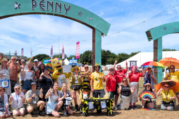 charity members posing for photo at Penny Lane site in Isle of Wight Festival