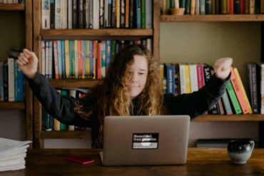 home educated girl working at table with computer by Annie Spratt