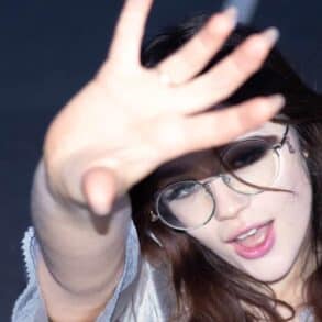 Maisy Dean holding her hand up to the camera