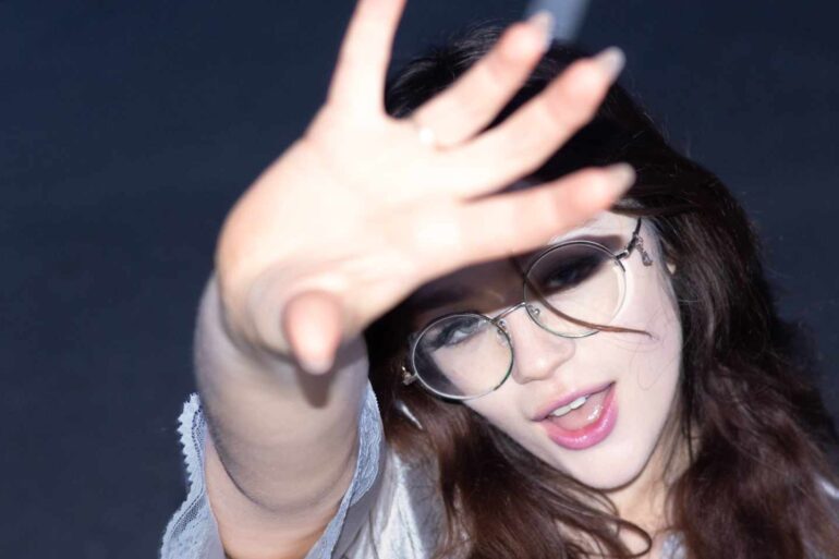 Maisy Dean holding her hand up to the camera