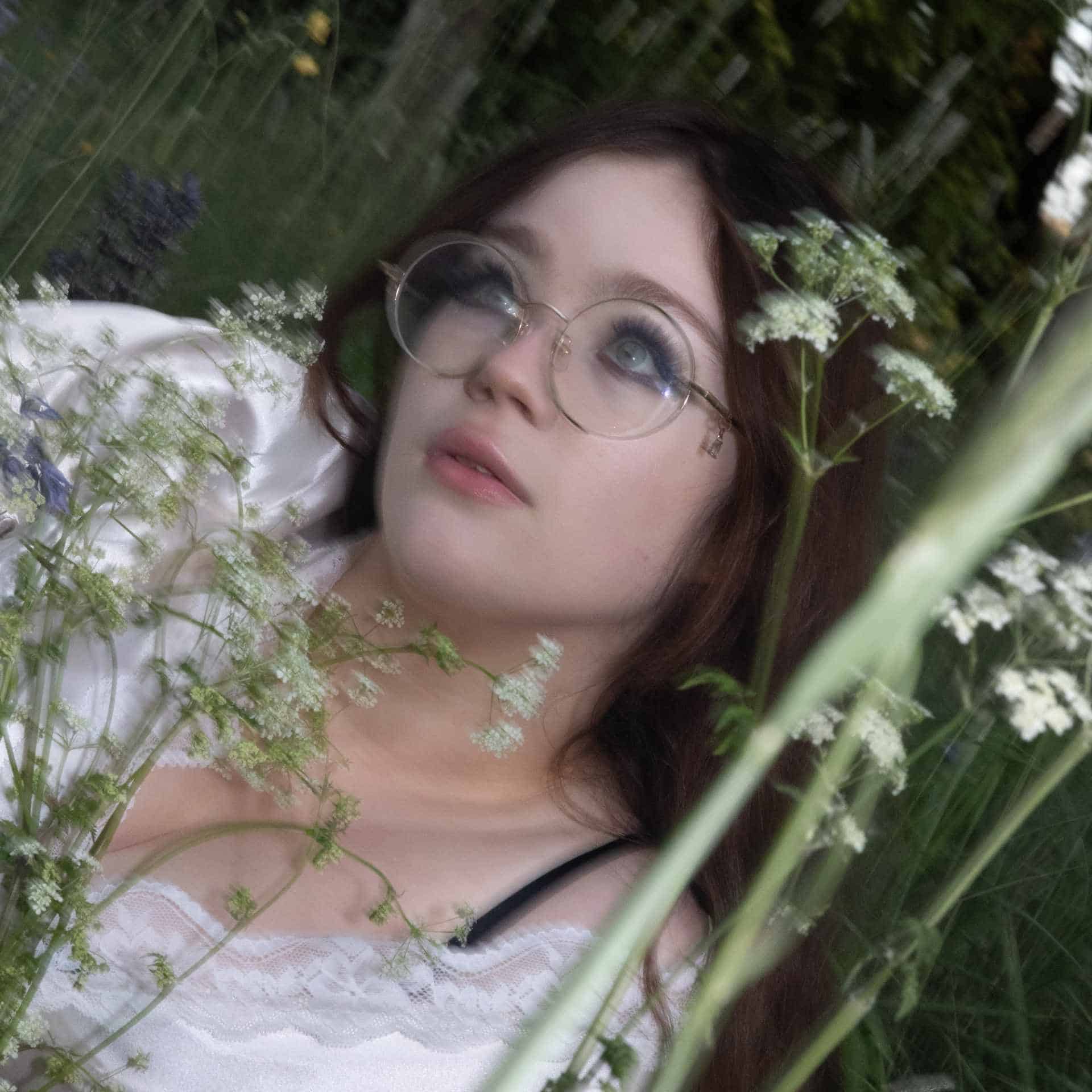 Maisy Dean sitting in a field of wildflowers