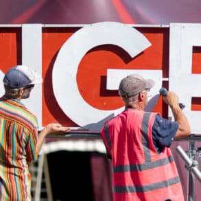 Two people constructing large signage for Ventnor's Fringe Festival