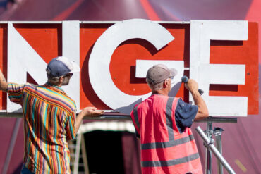 Two people constructing large signage for Ventnor's Fringe Festival