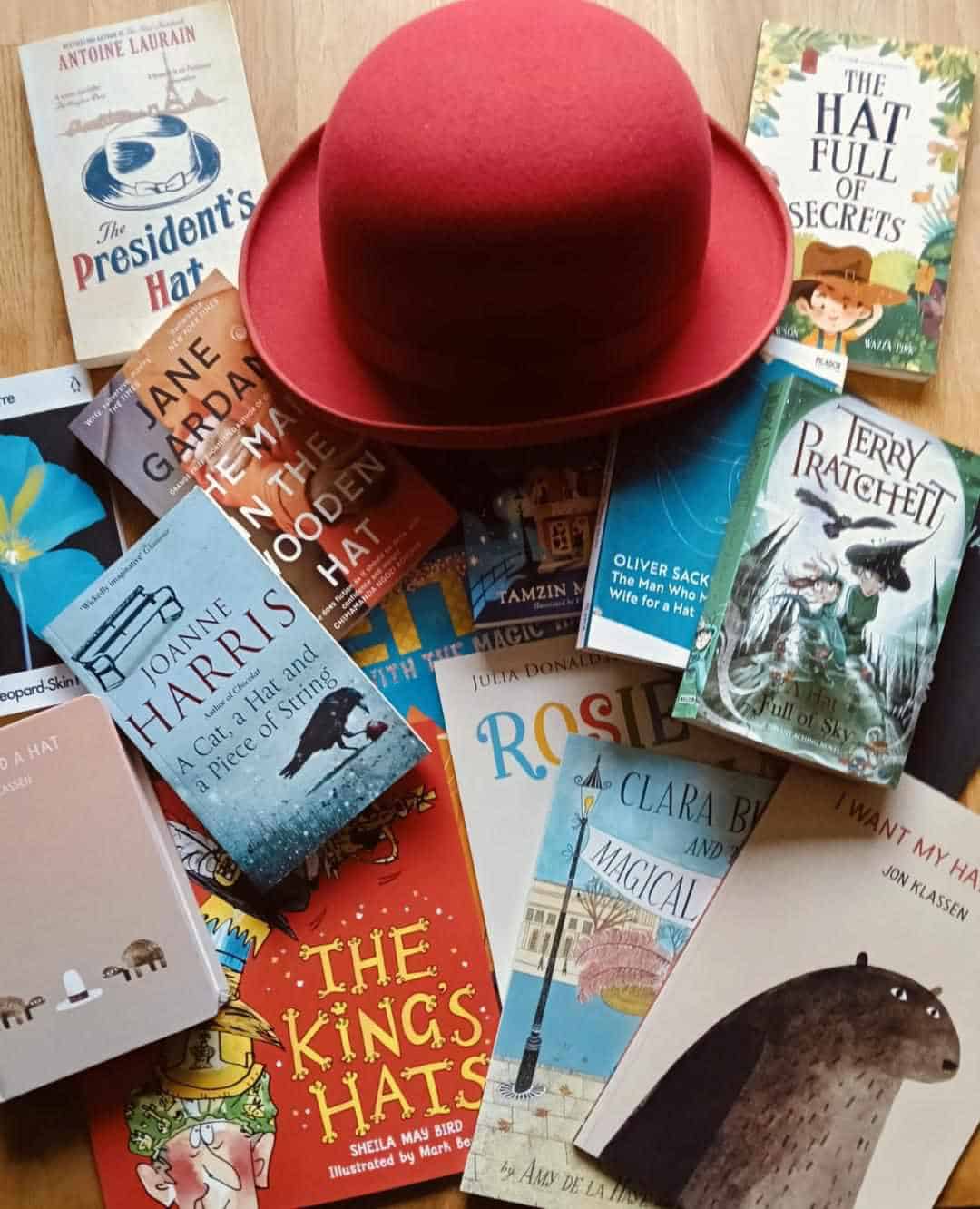 A range of hat-related books laid out with a bowler hat on top