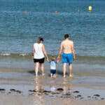 family paddling in the sea at Colwell Bay