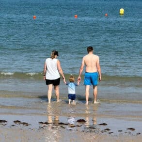 family paddling in the sea at Colwell Bay