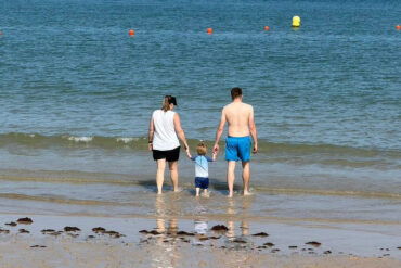 family paddling in the sea at Colwell Bay