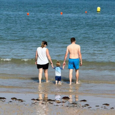 family paddling in the sea at Colwell Bay