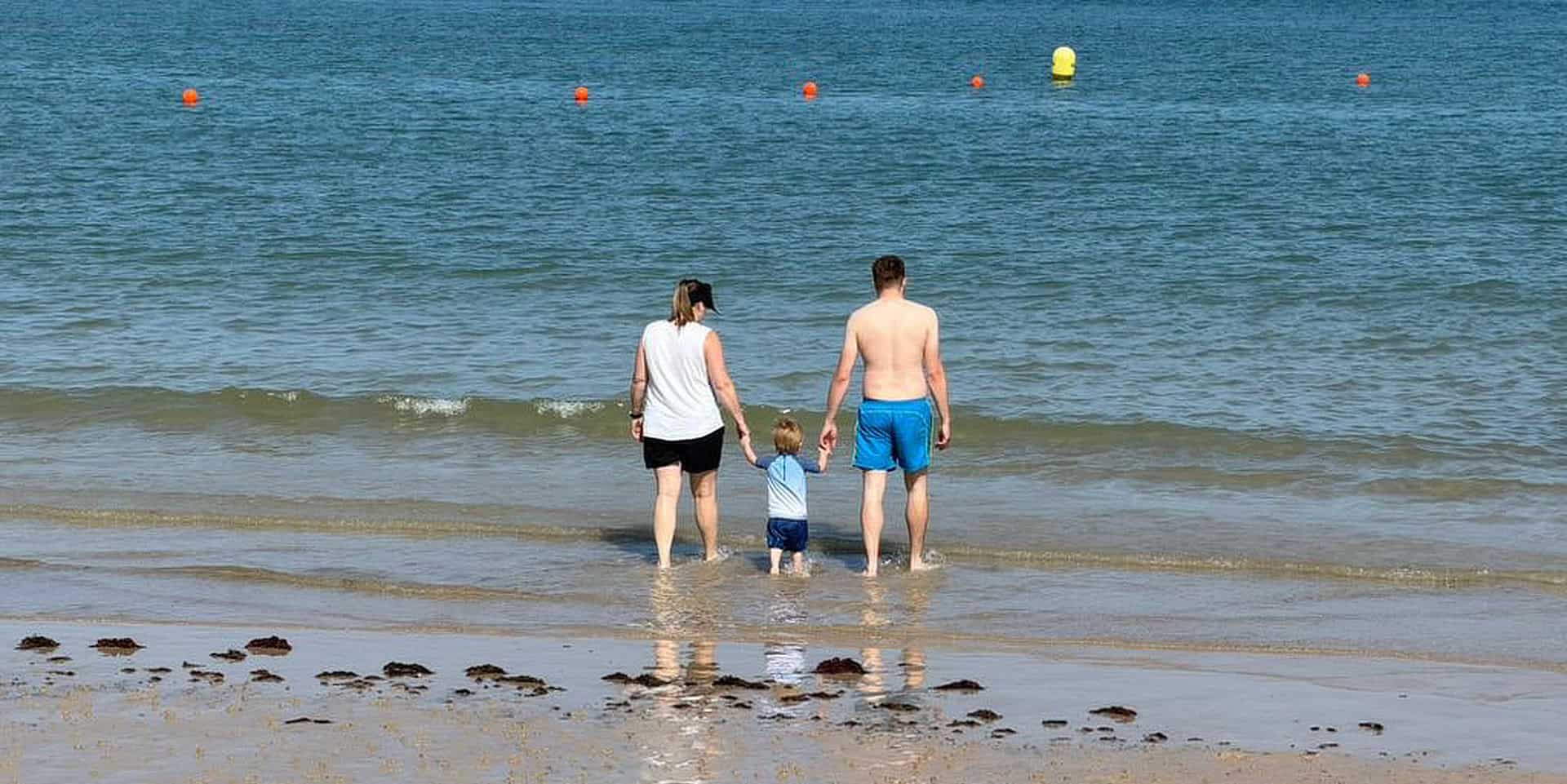 family paddling in the sea at Colwell Bay