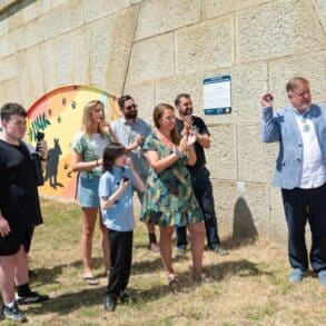 Pupils and dignitories attending the official opening of the murals