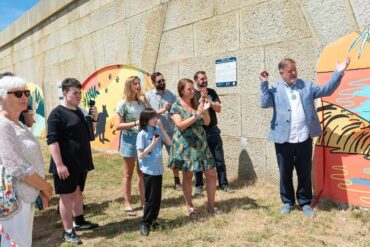 Pupils and dignitories attending the official opening of the murals