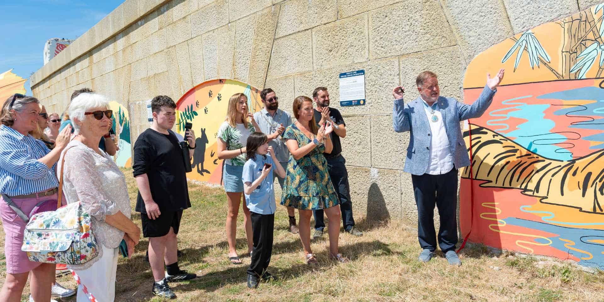 Pupils and dignitories attending the official opening of the murals