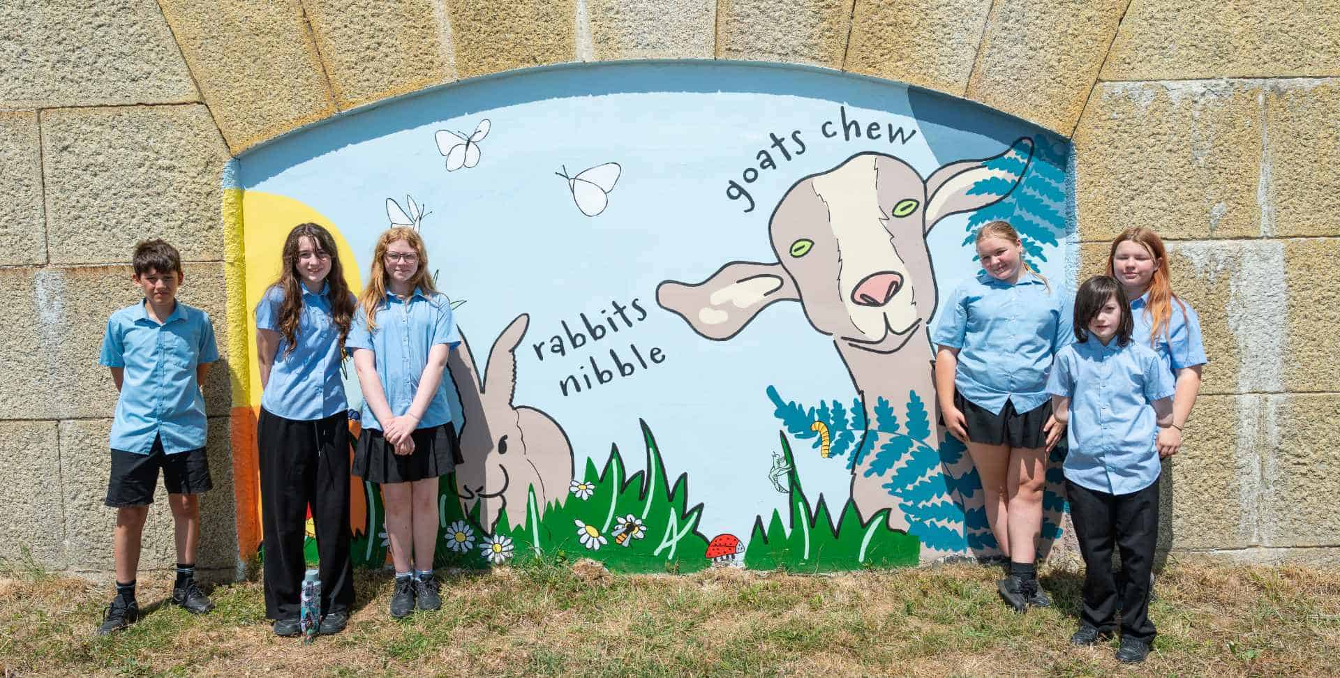 Pupils and dignitories attending the official opening of the murals