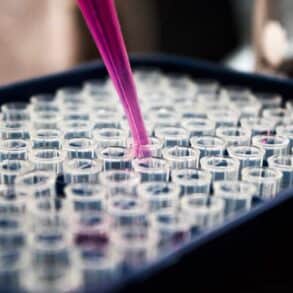 Lab technician putting liquid into test tubes