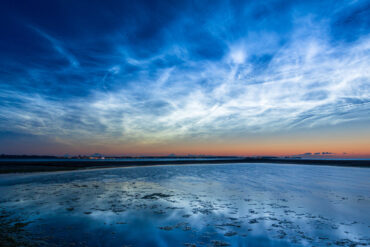 Noctilucent clouds over a beach