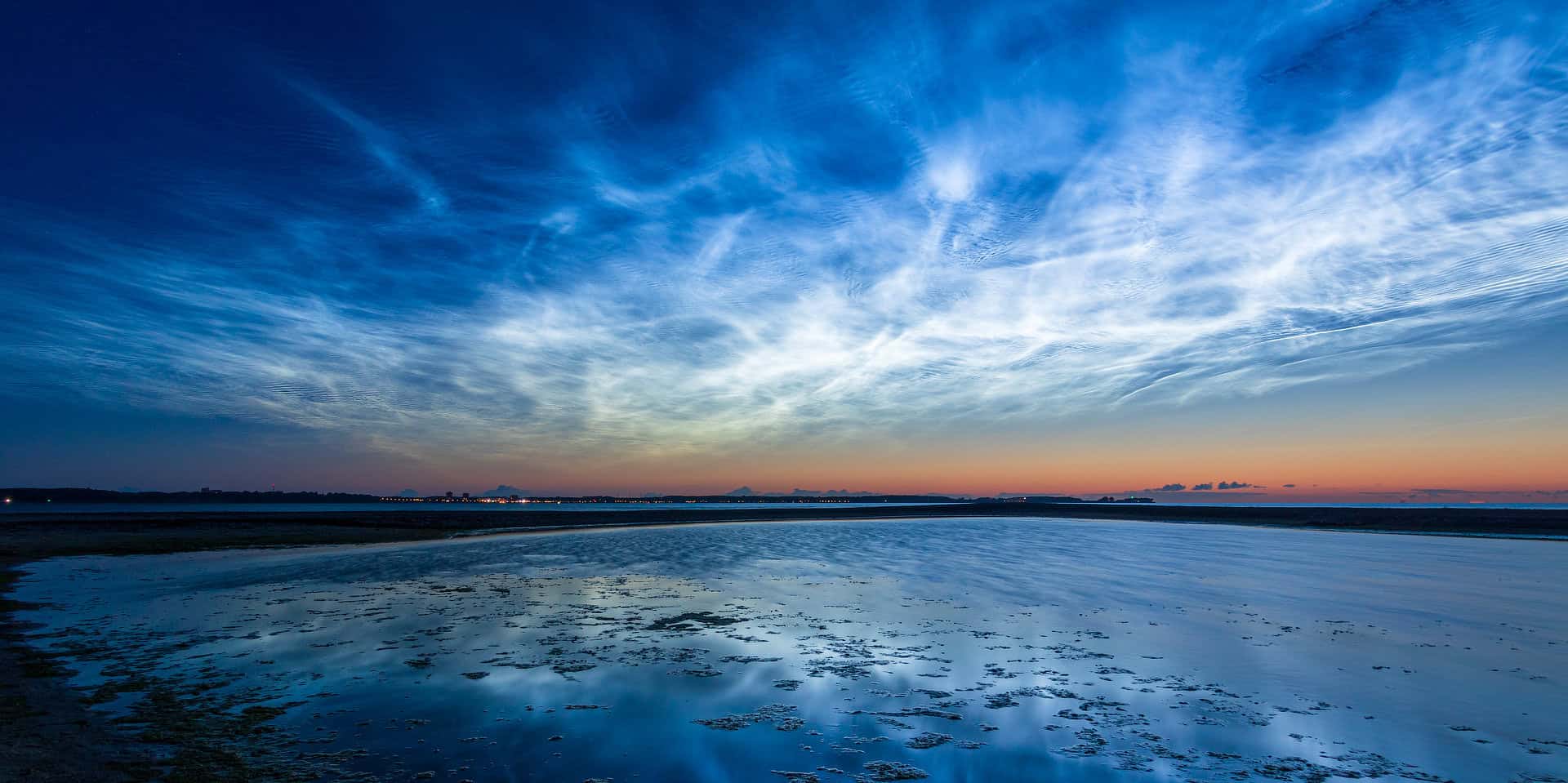 Noctilucent clouds over a beach