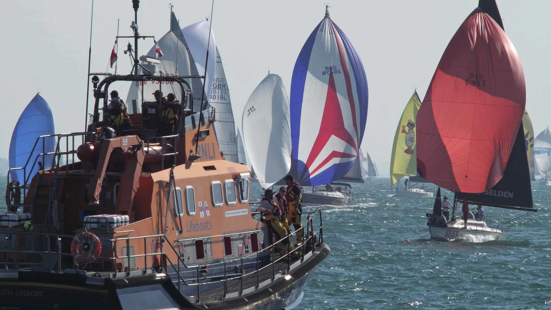 Boats with their colourful spinnakers up for Round the Island Race 2026 = RNLI looking on