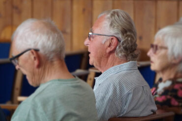 Photo of the backs of three people with Paul Wyatt in the centre