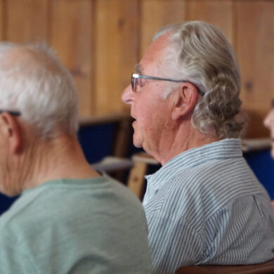 Photo of the backs of three people with Paul Wyatt in the centre