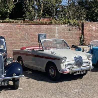 Singer Motor cars from three eras in a car park -