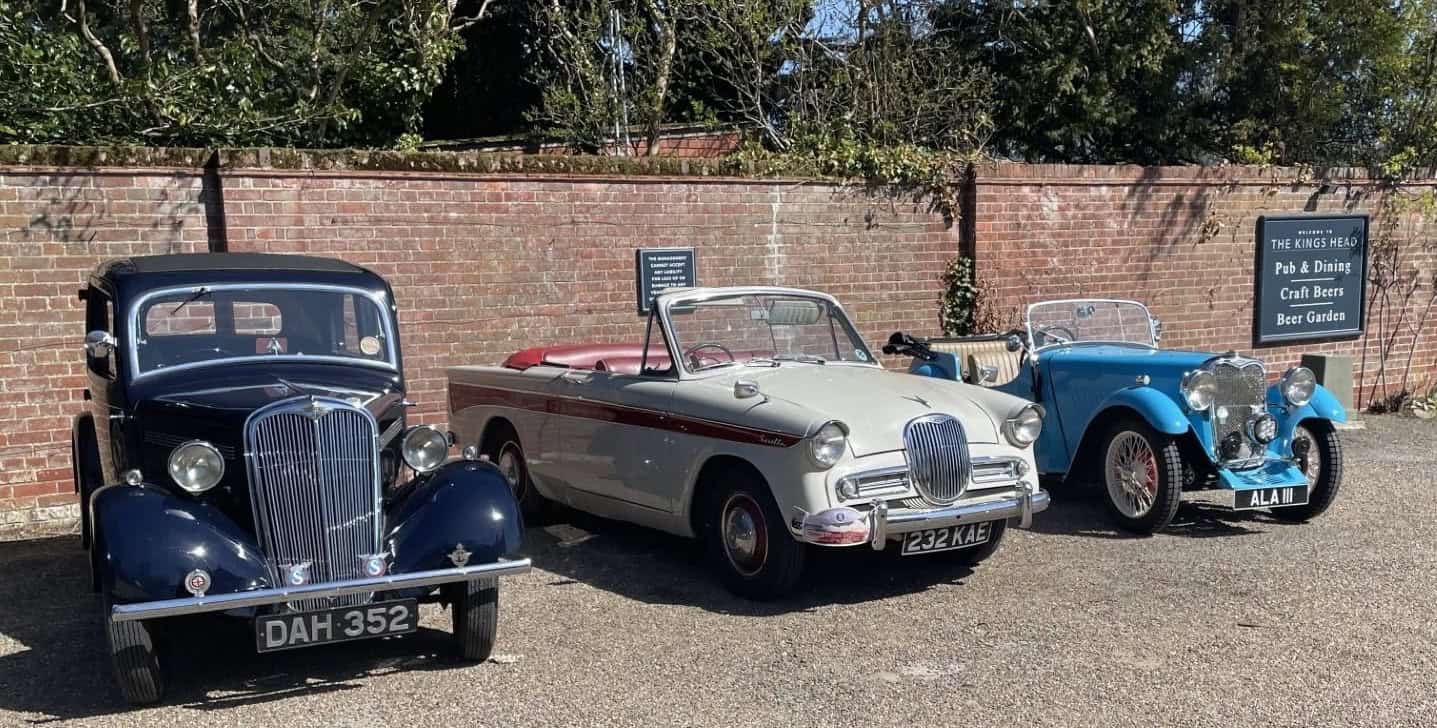 Singer Motor cars from three eras in a car park -