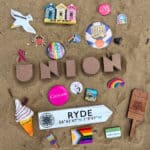 Front cover of Union book, showing sand, ice cream fridge magnet, badge and rainbow pins