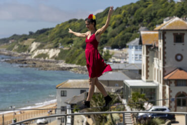 Tightrope walker on a tightrope with Ventnor bay in the background