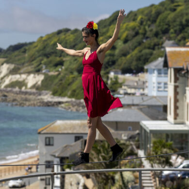 Tightrope walker on a tightrope with Ventnor bay in the background