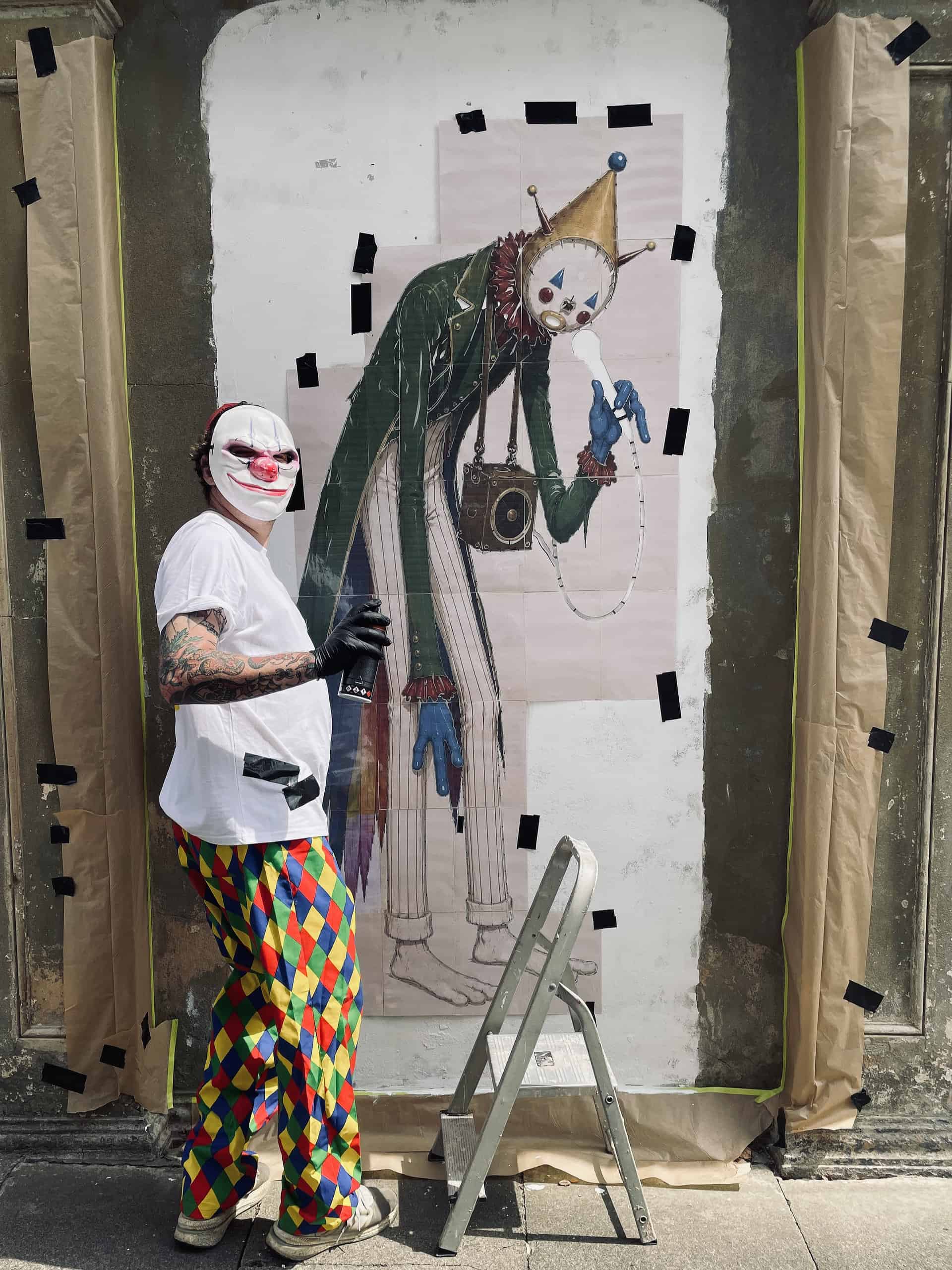 Masked graffiti artist preparing Sandown Clown street art