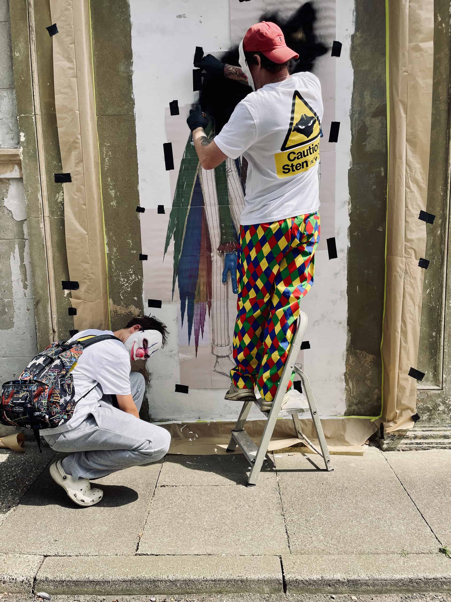 Masked graffiti artists preparing Sandown Clown street art