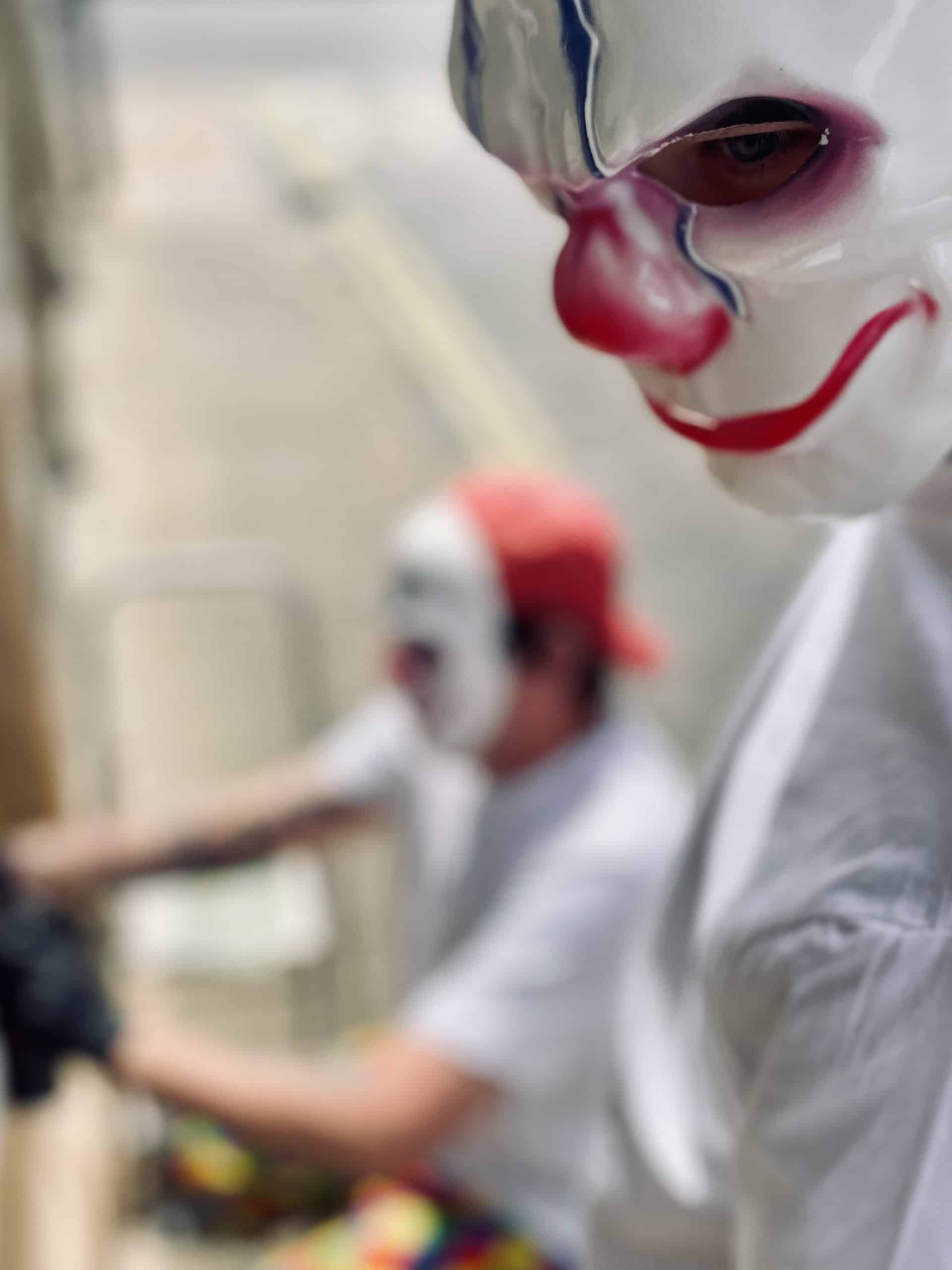 Blurred shot of masked graffiti artists preparing Sandown Clown street art