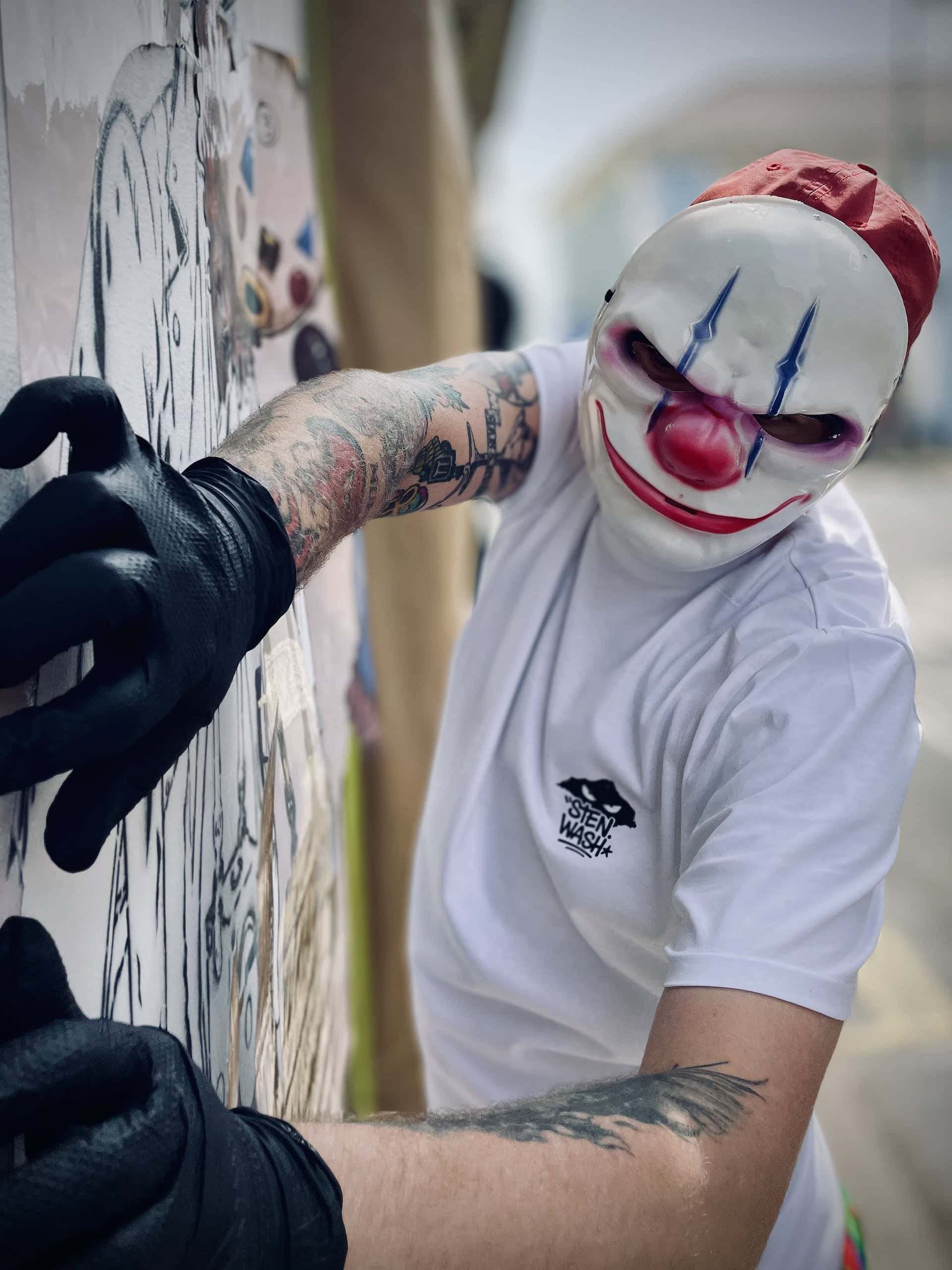 Masked graffiti artist preparing Sandown Clown street art