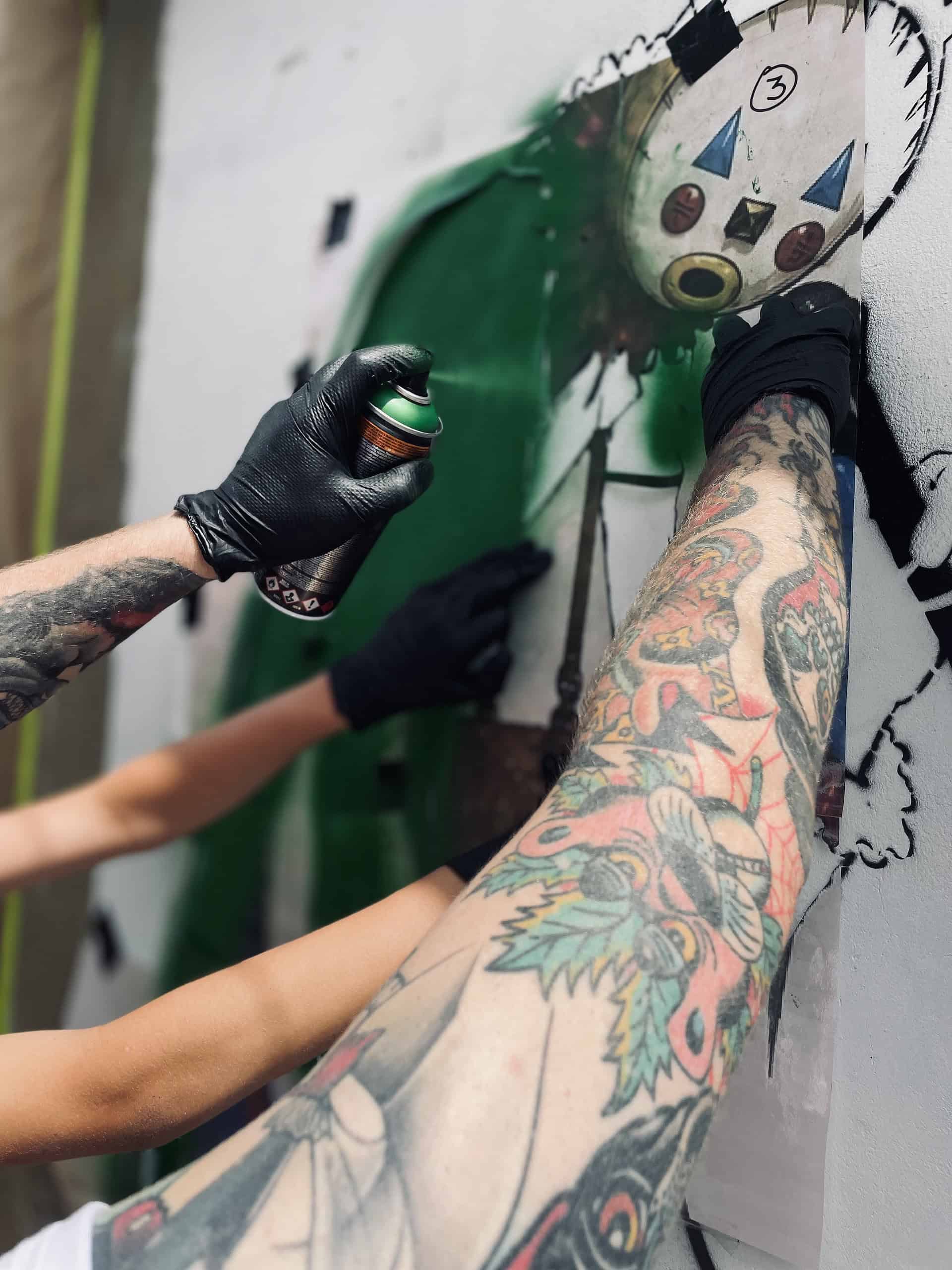 Masked graffiti artists spraying Sandown Clown street art