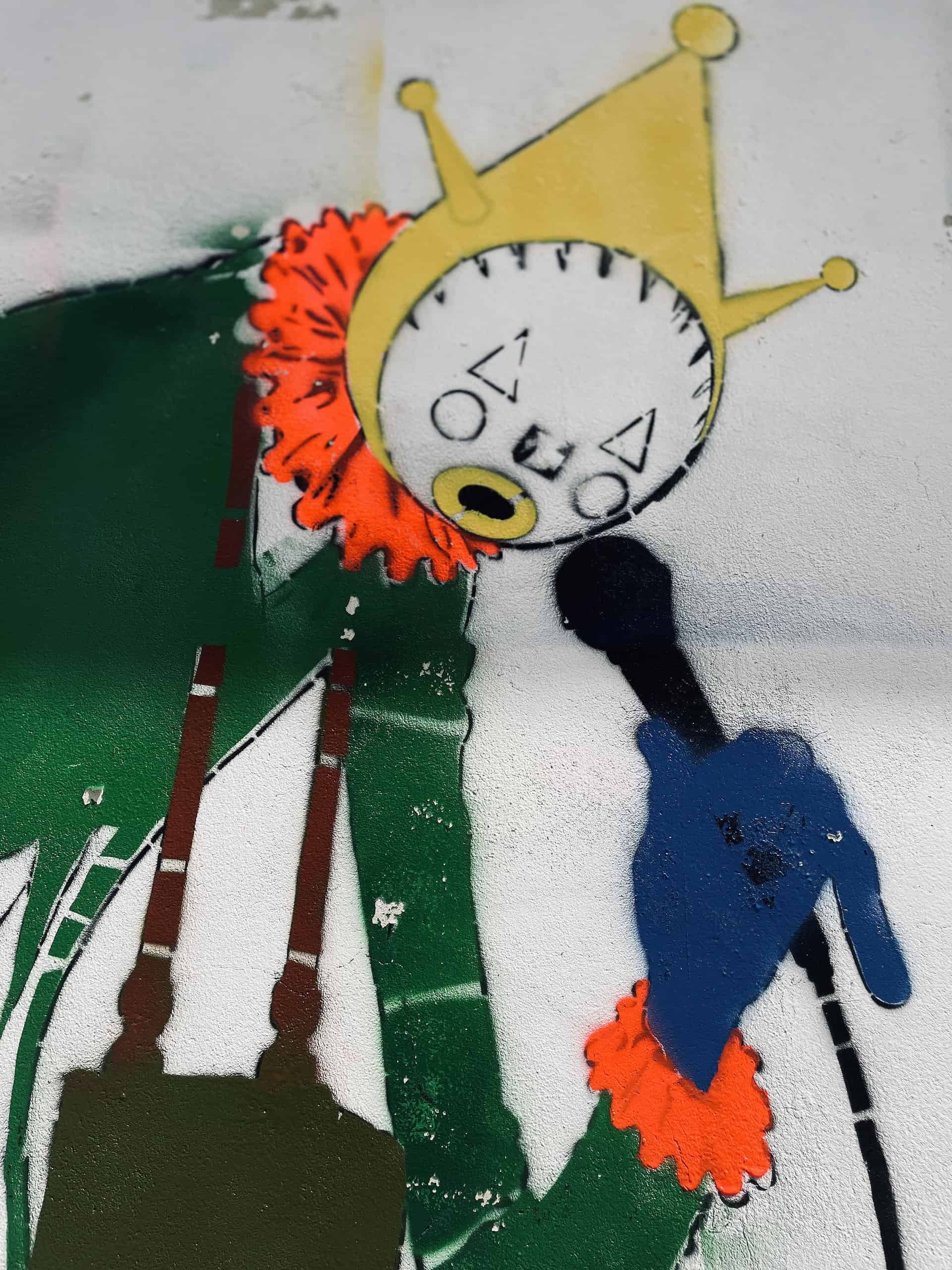 Masked graffiti artists spraying Sandown Clown street art