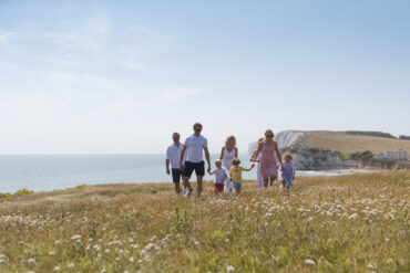 Family walking on hillside near freshwater bay -