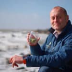 Xavier Baker from Isle of Wight distillery by the sea with a glass of Mermaid Gin and Tonic