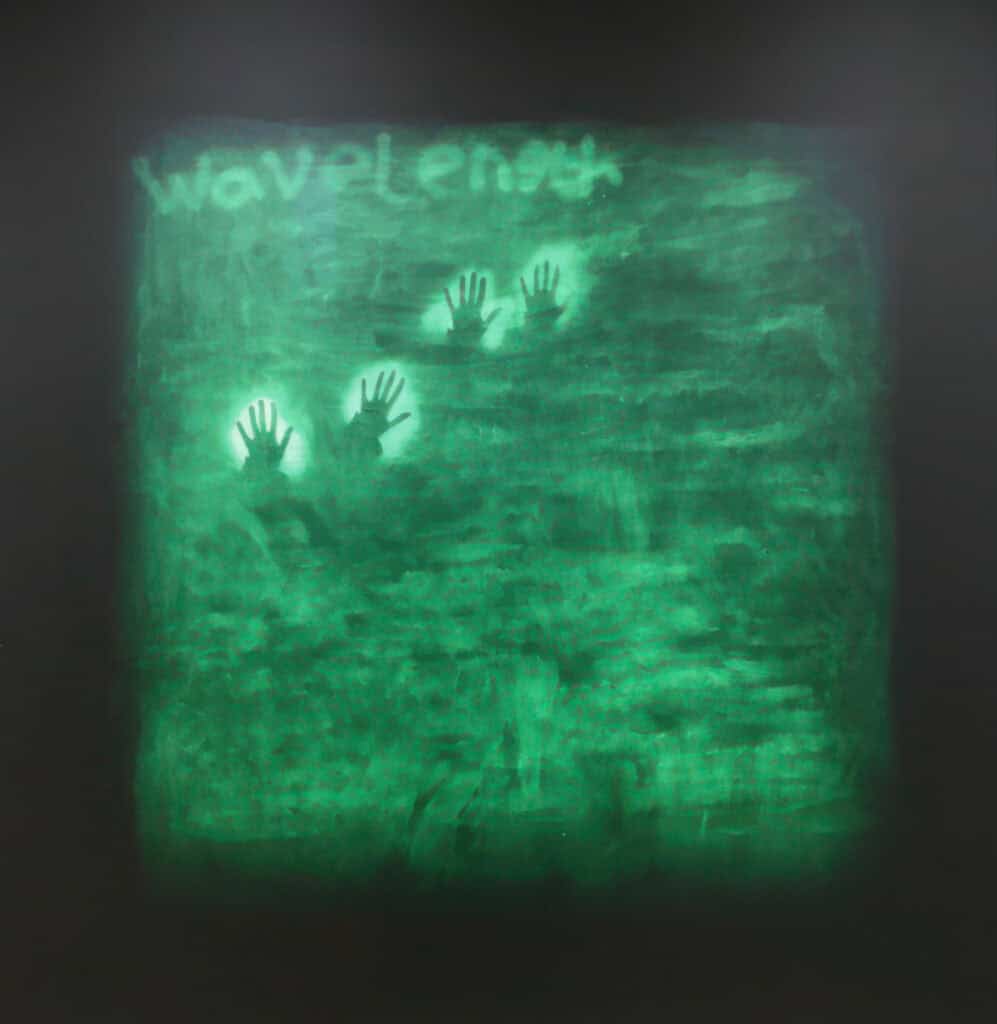 Green background with silhouette of hands and the words 'Wavelength'