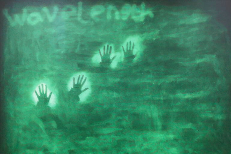 Green background with silhouette of hands and the words 'Wavelength'