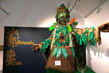 Large green man folk puppet in art gallery