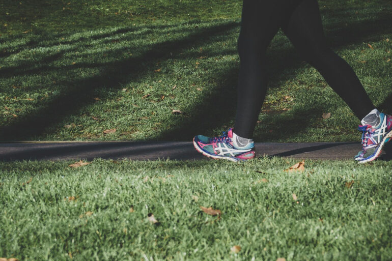 Woman jogging through a park