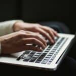 Woman typing on laptop keyboard