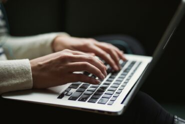 Woman typing on laptop keyboard