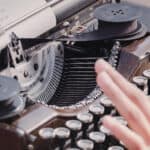 person typing a poem on a traditional typewriter