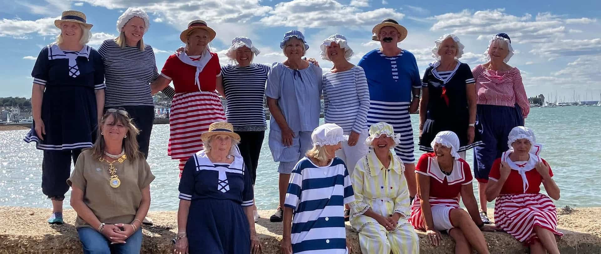 A group of women and men dressed up in victorian beachwear
