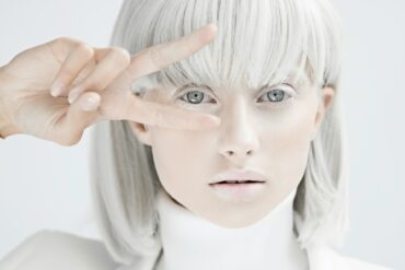 woman with silver hair, skin painted silver and silver clothes