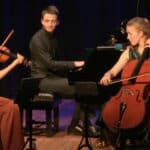 Amelio Trio playing instruments on stage