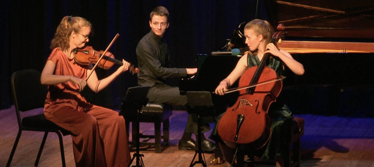 Amelio Trio playing instruments on stage