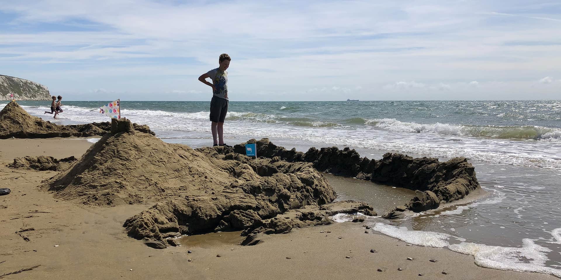 Boy standing watching the incoming tide at Sandown's Yaverland Beach