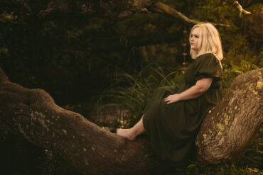 Lizzie Thomas sitting on a tree branch