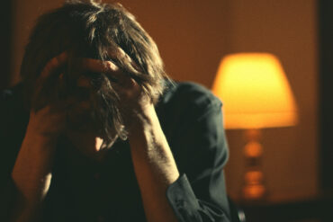 Man with head in hands looking frustrated